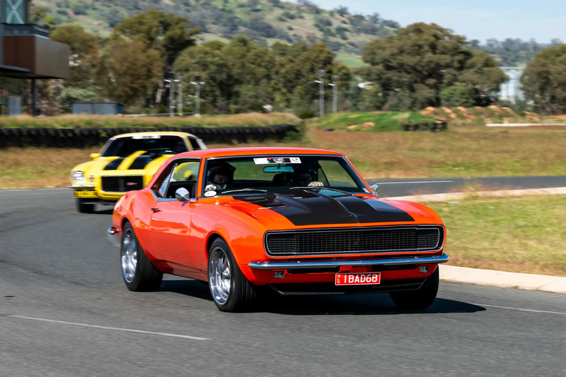 Orange first-generation Camaro leading another Camaro during the Camaro Firebird Nationals