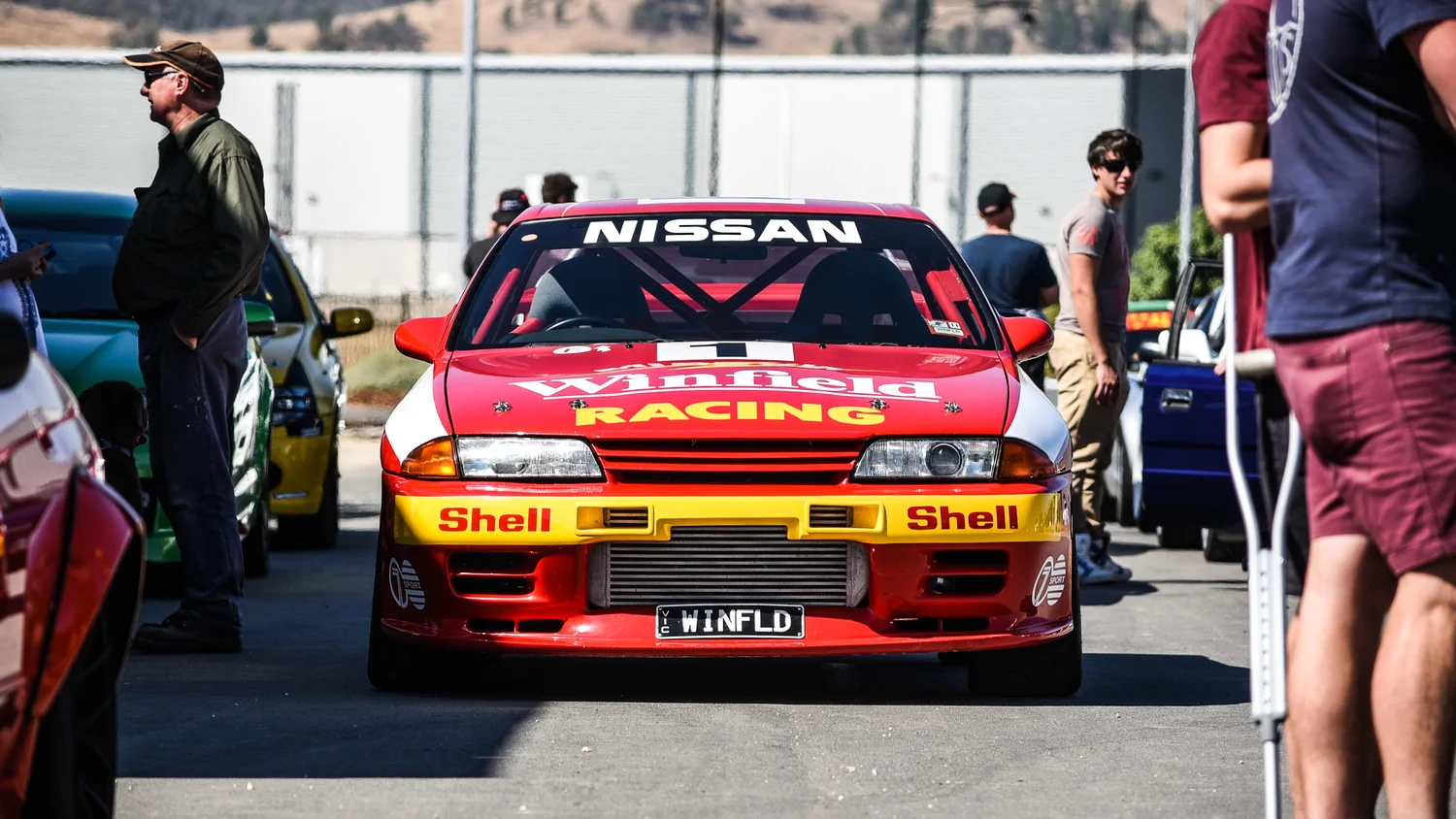 Red Nissan race car in the pit lane